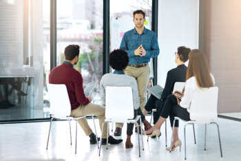 a group of employees listening to a counselor